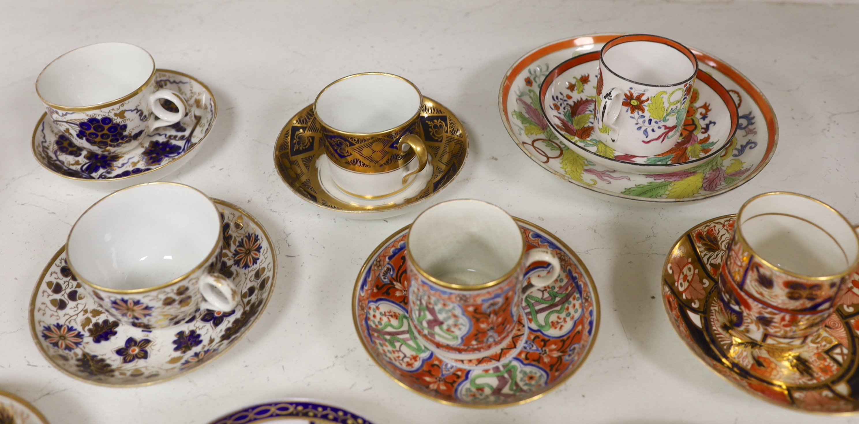 Six mixed English 1800-1820 porcelain cabinet cups and saucers, three similar coffee cans and saucers, a matching spoon stand and two coffee cans, a saucer dish, coffee can plus saucer and a tea bowl and matching saucer